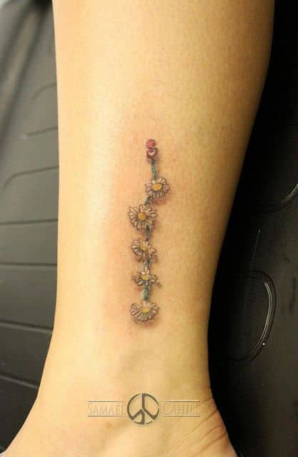 Tiny Daisy tattoo on women leg