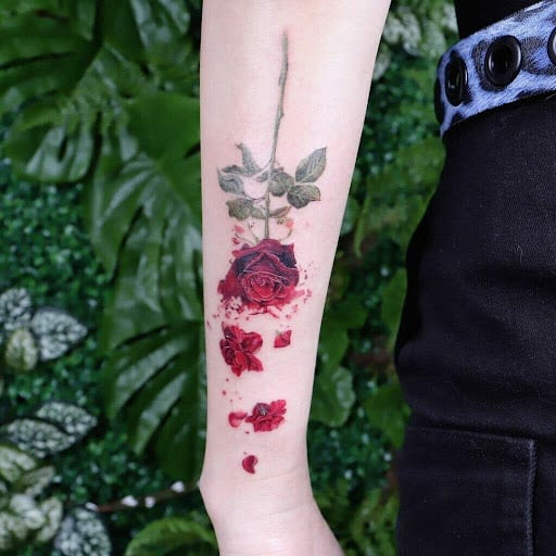 Upside-down red rose tattoo