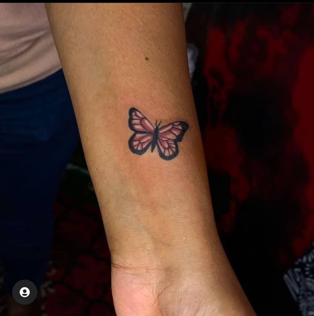 pink butterfly tattoo on wrist